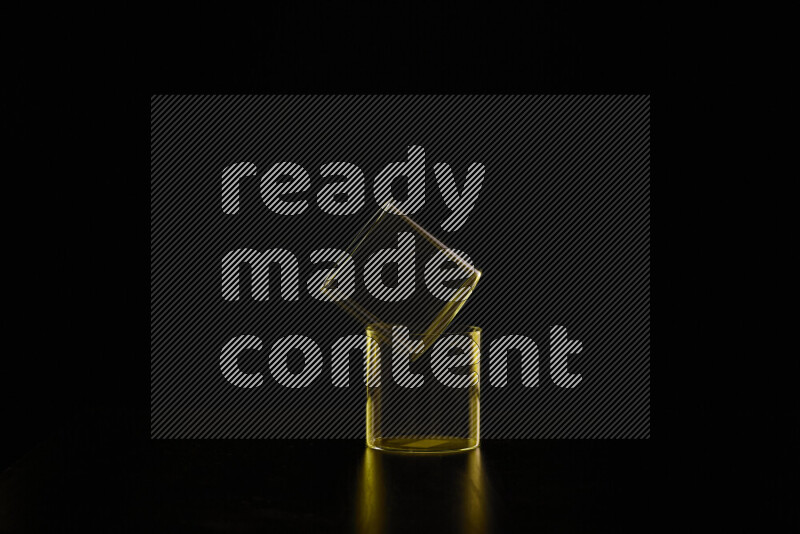 Glassware with rim light in yellow against black background