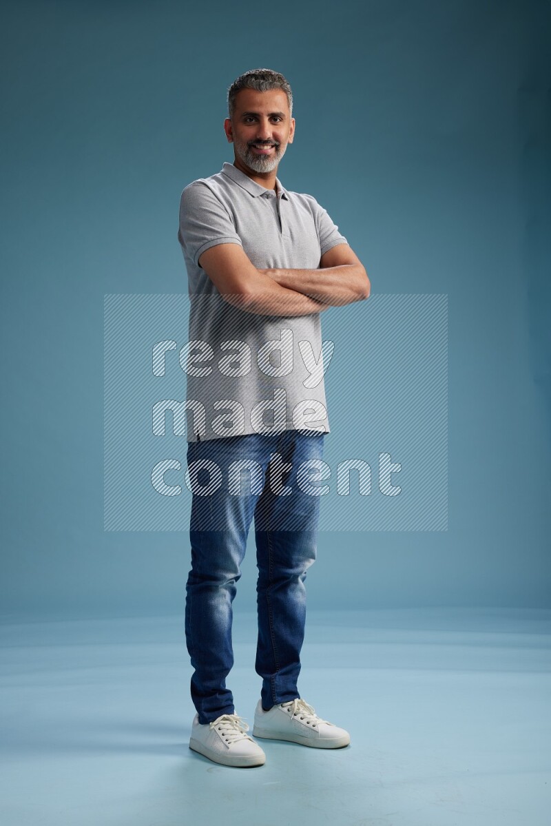 Man Standing Interacting with the camera on blue background