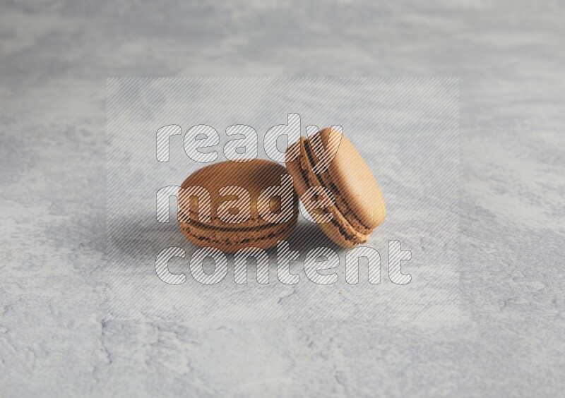 45º Shot of two Brown Coffee macarons  on white  marble background