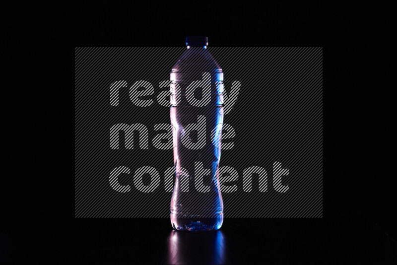 Water bottle with colored rim light against black background