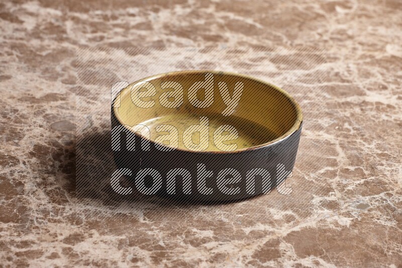 وعاء فرن فخاري متعدد الألوان علي خلفية رخام بيج