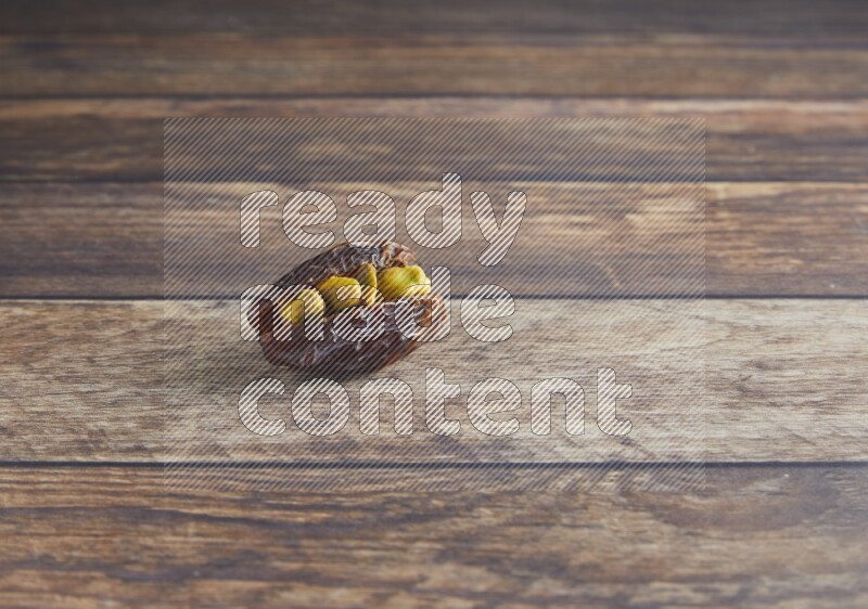 pistachio stuffed madjoul date on a wooden background