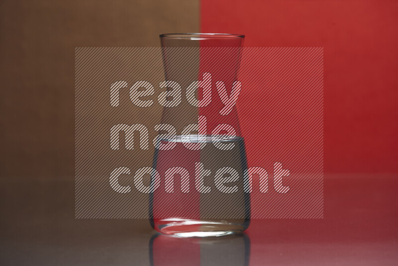 The image features a clear glassware filled with water, set against brown and red background