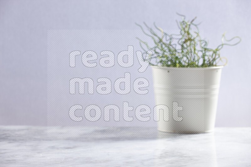 Artificial plant in white pot on grey marble background