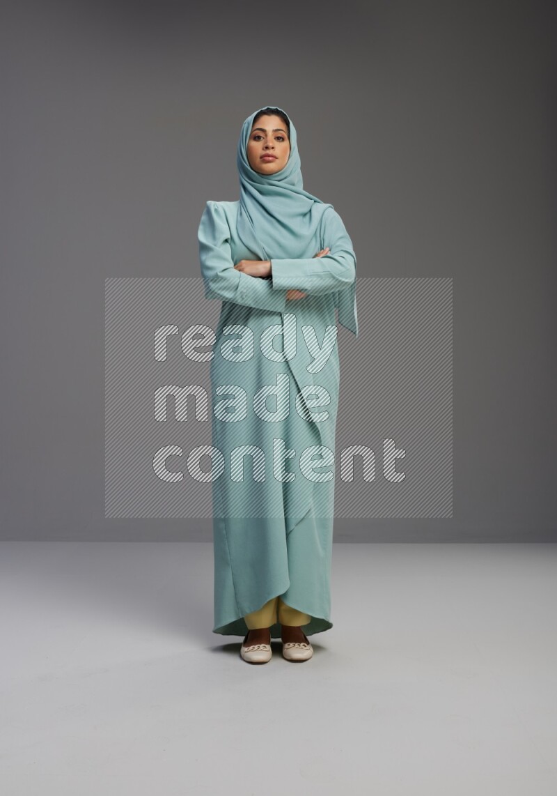 Saudi Woman wearing Abaya standing with crossed arms on Gray background