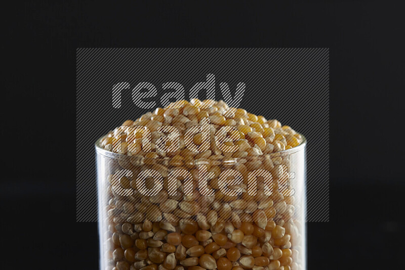 Pop corn in a glass jar on black background