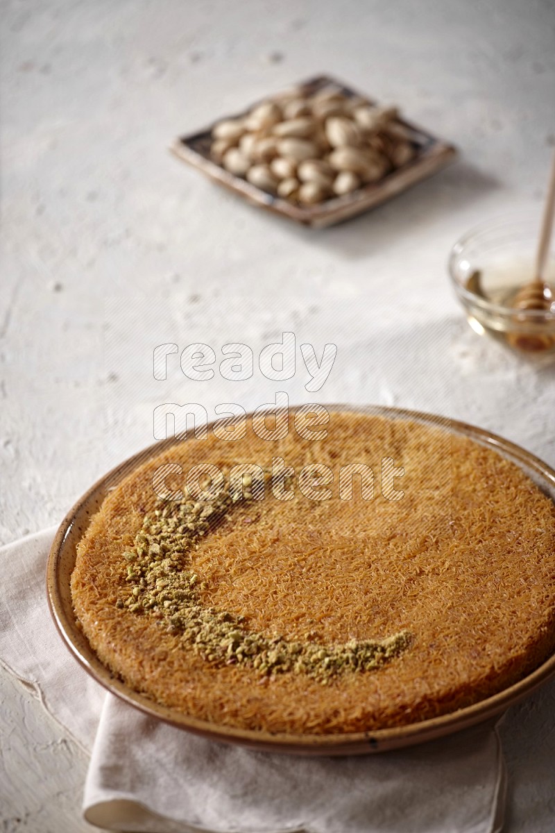Konafa with nuts and honey in a light setup