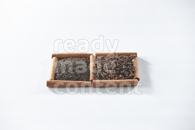 2 squares of cinnamon sticks full of black tea and cloves on white flooring