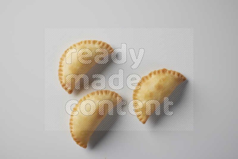 Three fried sambosa from a top angle on a white background
