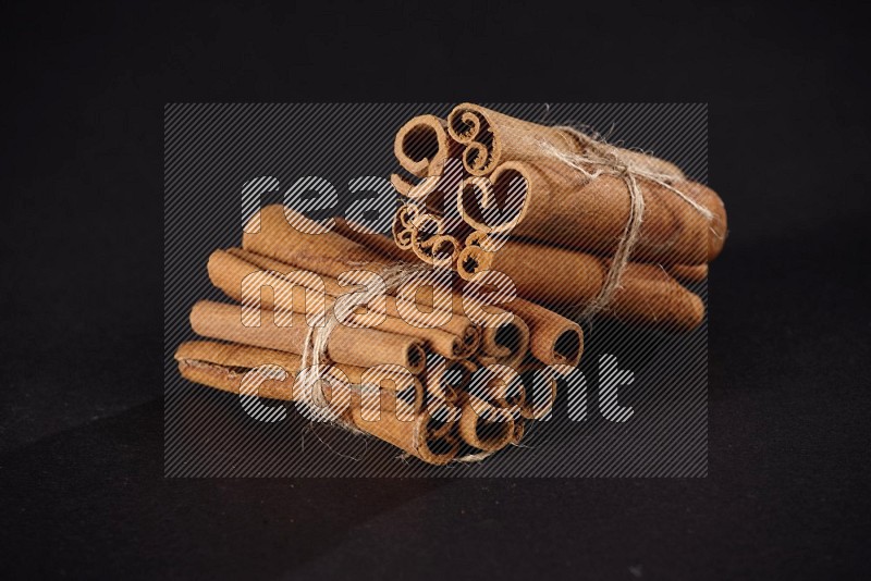 Two bounded stacks of cinnamon sticks on black background
