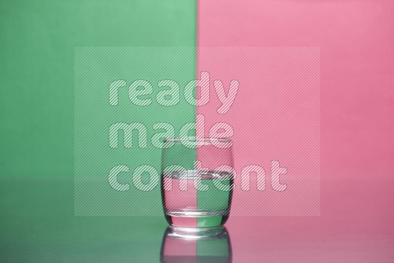 The image features a clear glassware filled with water, set against green and pink background