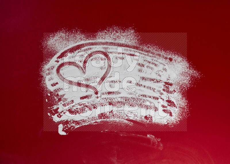 A heart drawn with powder on red background