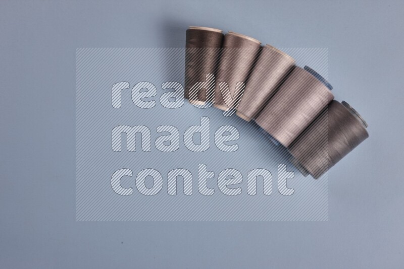 A grey collection of sewing and tailoring tools arranged on a blue background