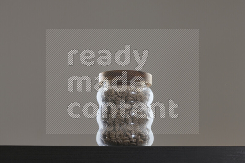 Buttons in a glass jar on black background