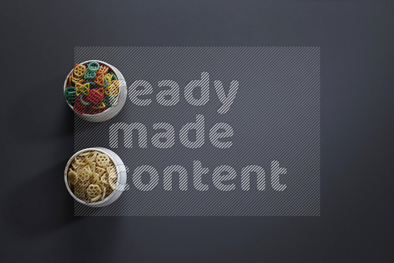 Legumes in pottery bowls on grey background