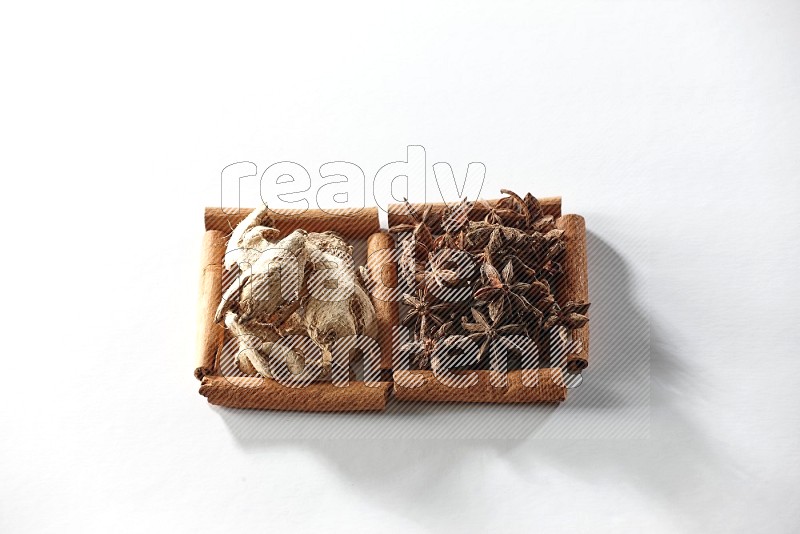 2 squares of cinnamon sticks full of star anise and dried ginger on white flooring