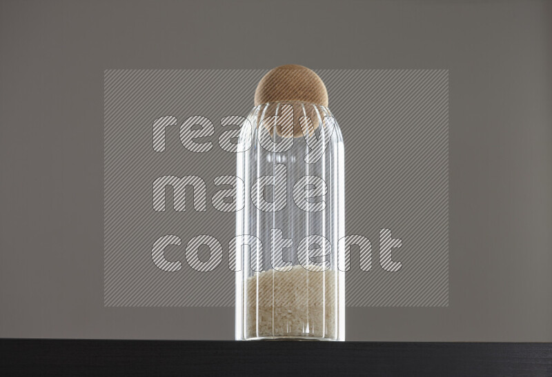 White rice in a glass jar on black background