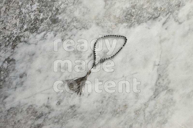 Prayer beads on grey marble background