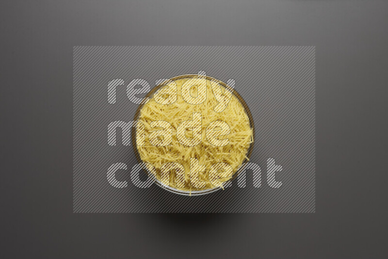 Vermicelli pasta in a glass bowl on grey background