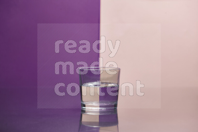 The image features a clear glassware filled with water, set against purple and rose background