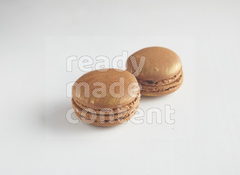 45º Shot of two Brown Coffee macarons on white background