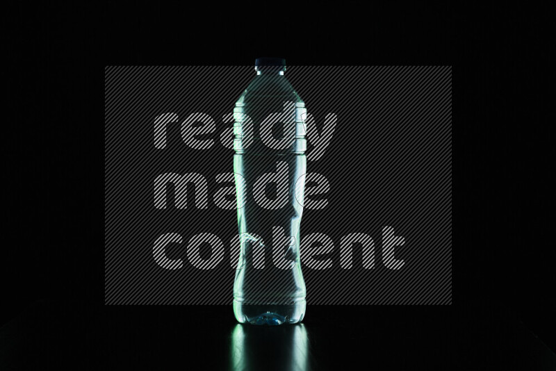 Water bottle with colored rim light against black background