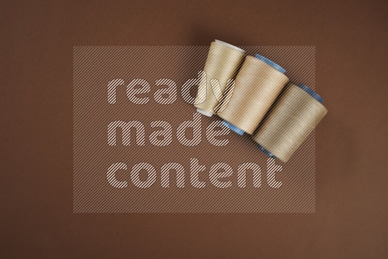 A brown collection of sewing and tailoring tools arranged on a brown background
