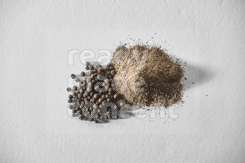 Black pepper powder and beads on a white background