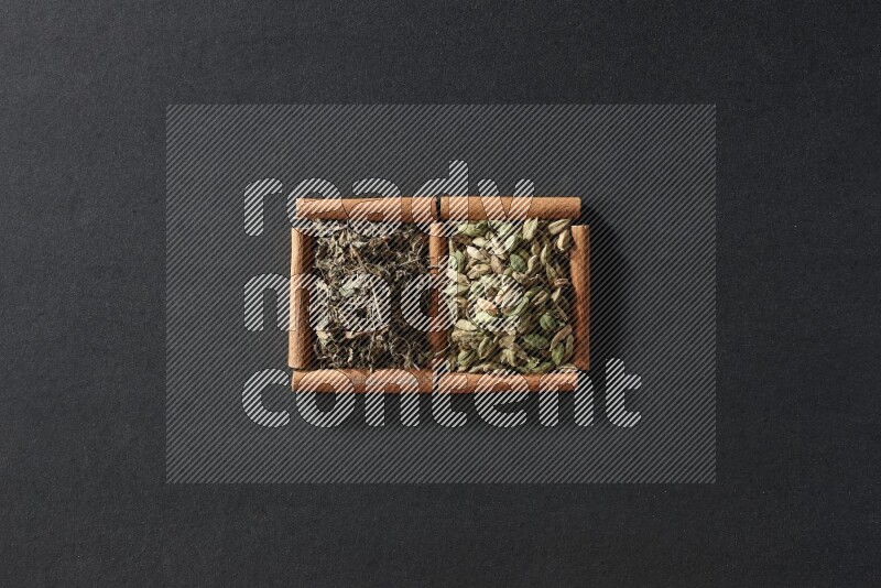 2 squares of cinnamon sticks full of cardamom and dried basil on black flooring