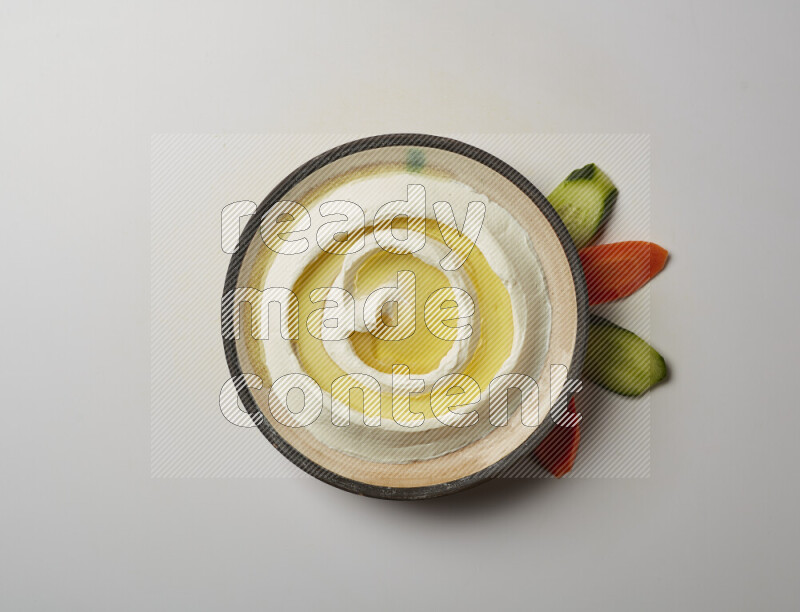 Lebnah garnished with olive oil in a pottery plate on a white background