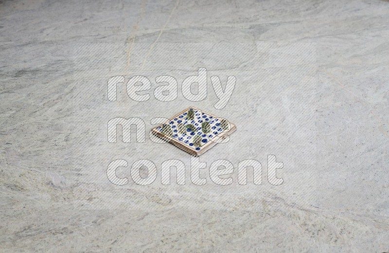 Top view shot of a pottery coaster\ tile on beige marble flooring