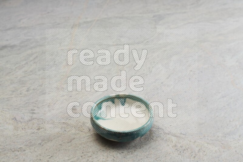 A multicolored pottery bowl on grey marble background