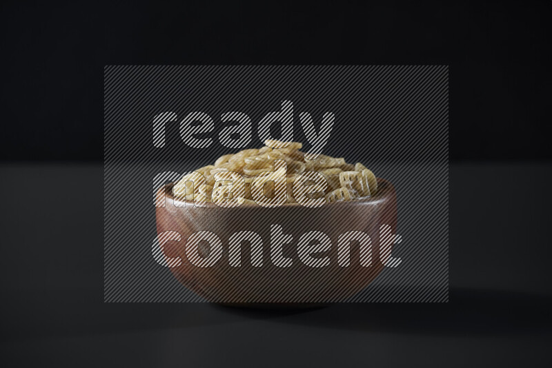 Snacks in a wooden bowl on grey background