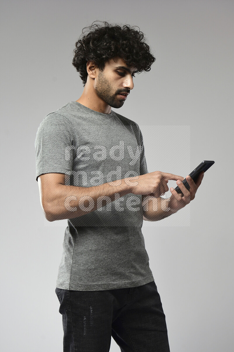 رجل يرتدي ملابس كاجوال يتصفح الهاتف علي خلفية بيضاء