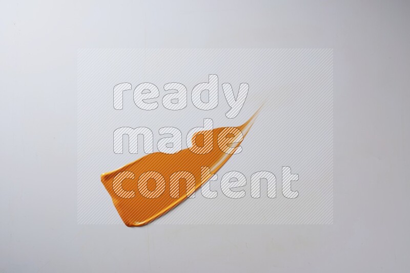 An orange single curved painting knife stroke on white background