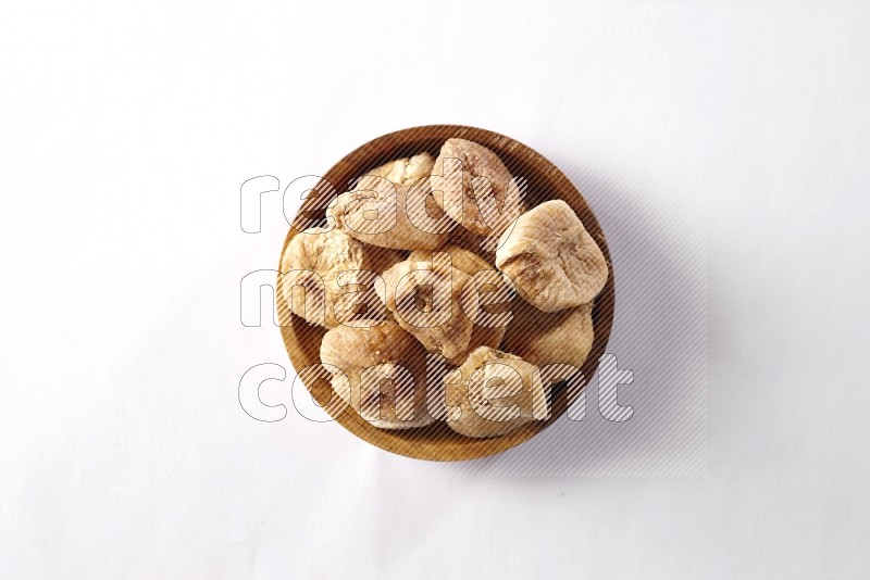 Dried figs in a wooden bowl on white background