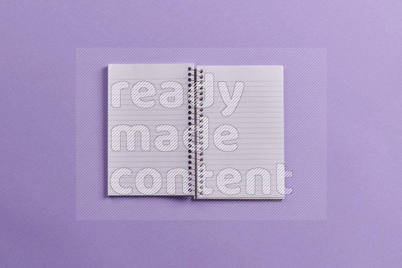 A blank open notebook with school supplies on purple background (Back to school)