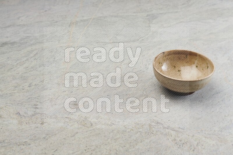 A multicolored pottery bowl on grey marble background