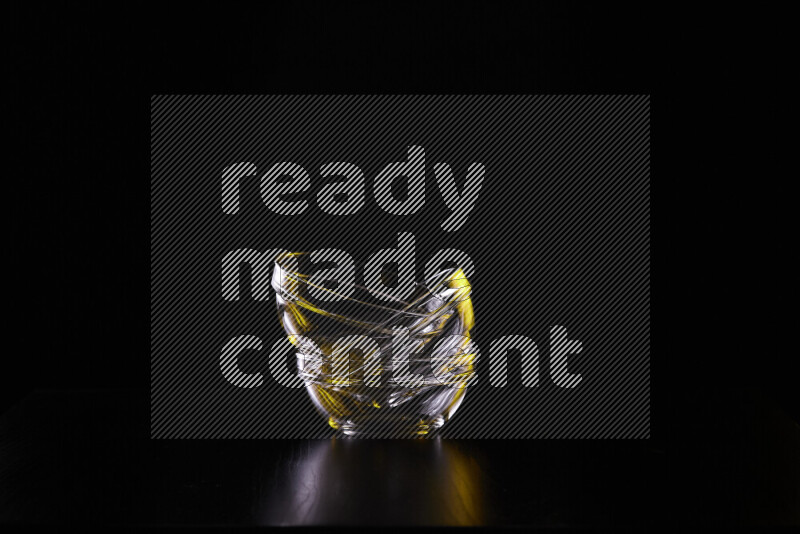 Glassware with rim light in yellow and white against black background