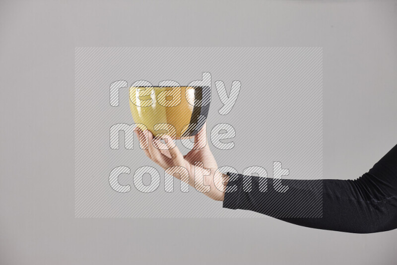 A woman in black abaya holding different pottery essentials in different positions