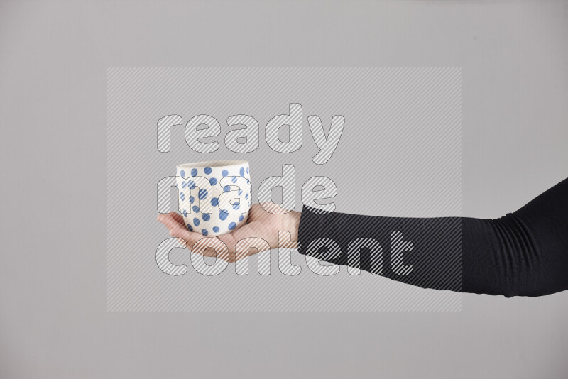 امرأة ترتدي عباءة سوداء تحمل أدوات فخارية مختلفة في أوضاع متعددة