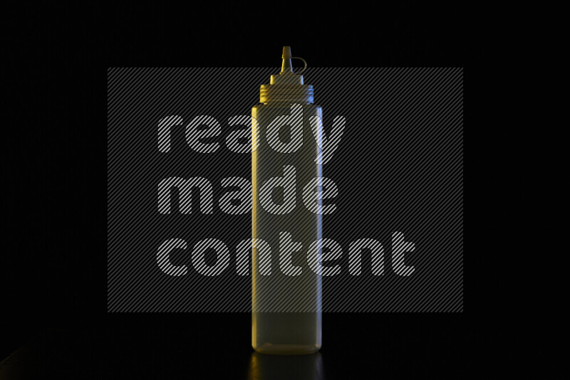 A squeeze bottle with colored rim light against black background