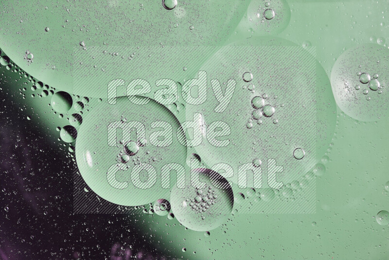 Close-ups of abstract oil bubbles on water surface in shades of black and green