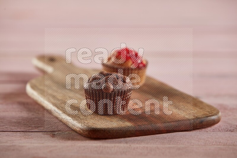 Chocolate mini cupcake topped with chocolate chips on a wooden board