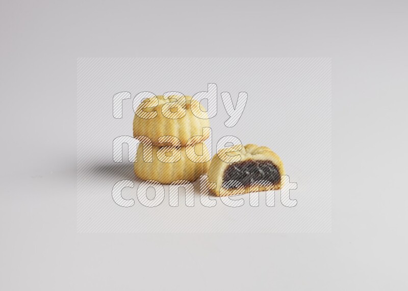 Three Pieces of Maamoul filled with date one of them is cut direct on white background