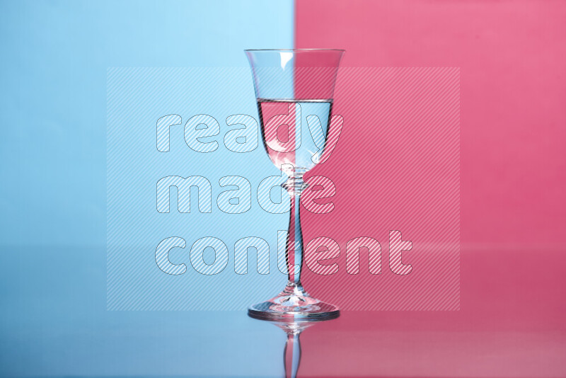 The image features a clear glassware filled with water, set against light blue and pink background