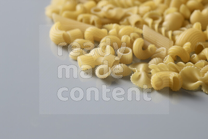Different pasta types on light blue background