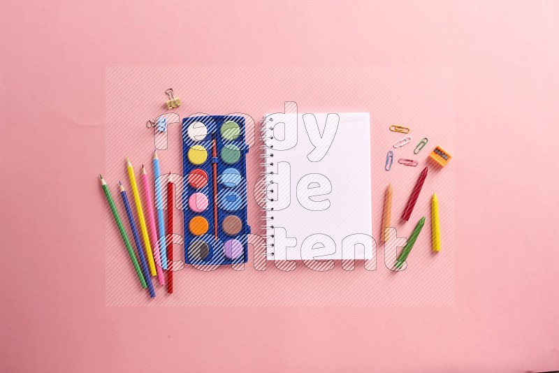 A blank open notebook with color pens on rose background (Back to school)