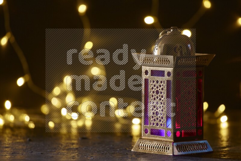 A traditional ramadan lantern surrounded by glowing fairy lights in a dark setup
