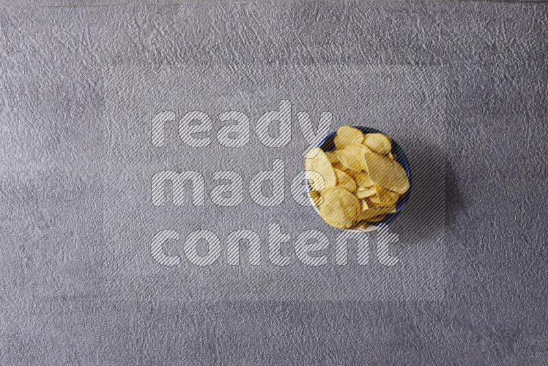 Assorted snacks in pottery bowls on grey background